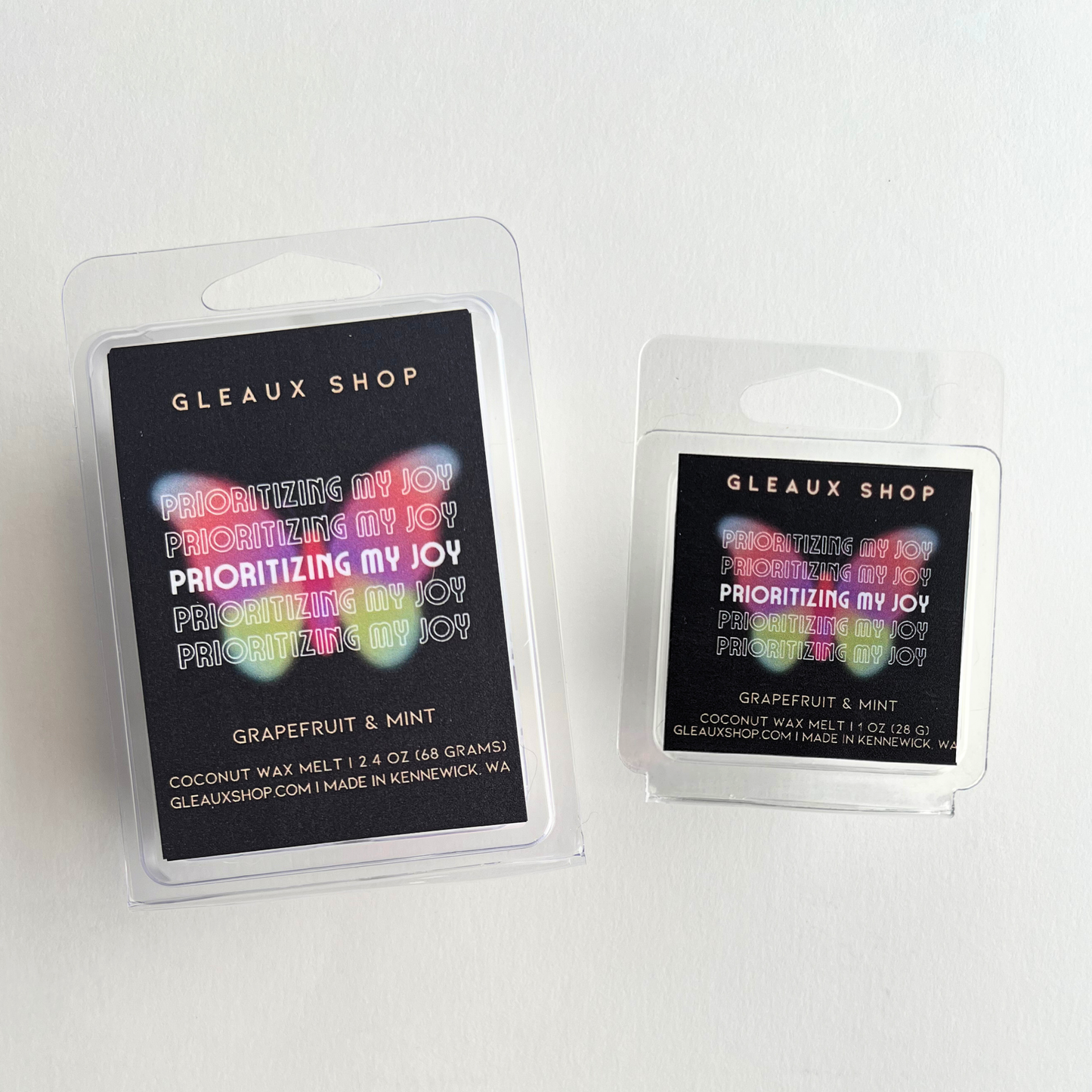 Packaging of Gleaux Shop's Grapefruit & Mint scented coconut wax melts with a window displaying the multicolored wax tarts inside. The packaging has a black background with product information and branding.